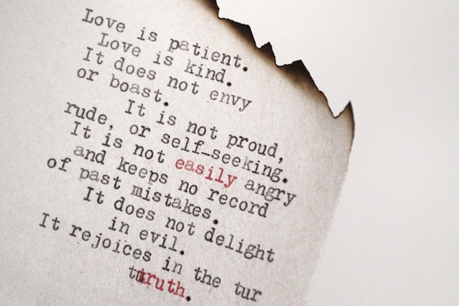 A partially burned piece of paper with a poem about love typed on it
